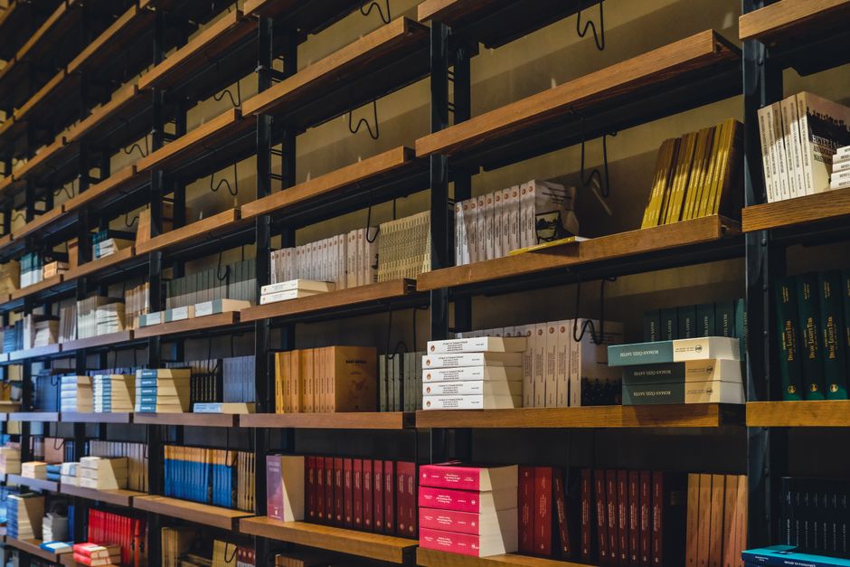 Diverse collection of books on a library shelf in Dhaka, Bangladesh.